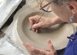 Andrea Leigh working in the window of the BCB Studio in Stoke-on-Trent.