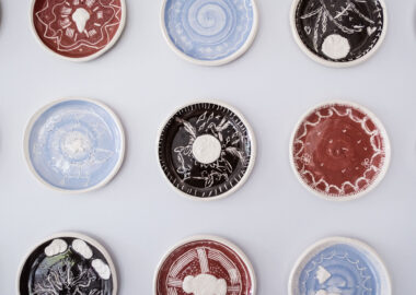 Sgraffito plates hung on a wall as part of the Transferer exhibition, Ceramic Minds.