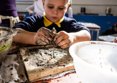 A child with messy hands playing with clay.